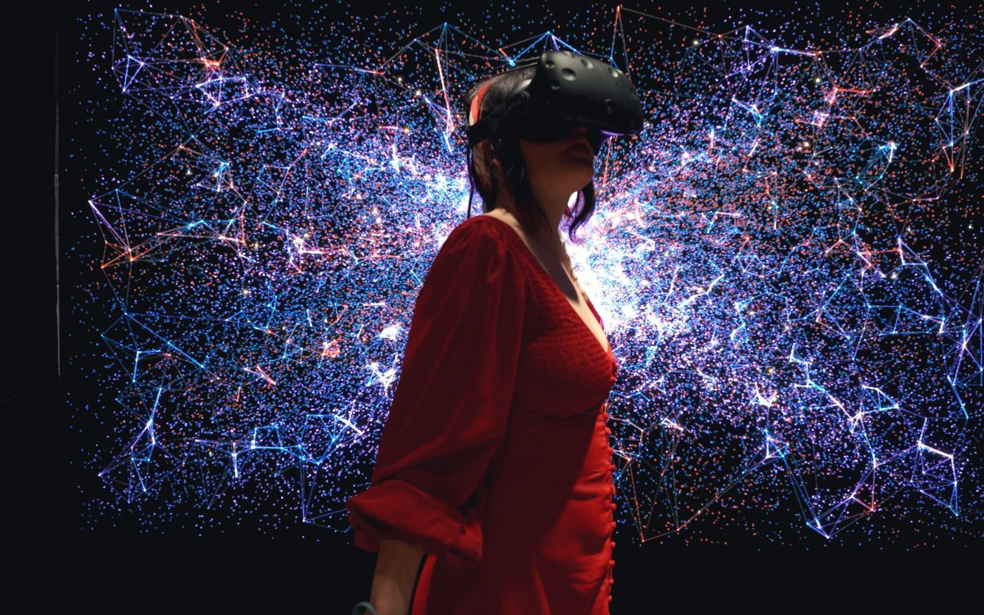Mujer con visor de realidad virtual frente a una red de luces